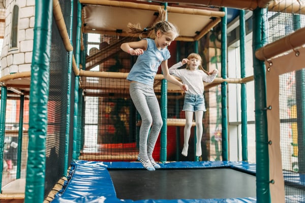 Two children bouncing on a trampoline